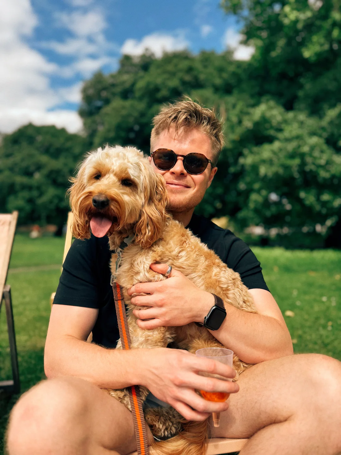 Dewey the cockapoo enjoying a cuddle outdoors on a sunny day